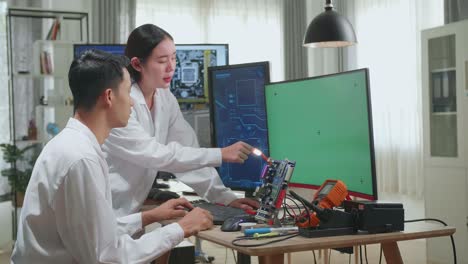 two engineers collaborating on a computer circuit board project.