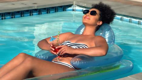 woman relaxing on floating pool lounger in swimming pool 4k