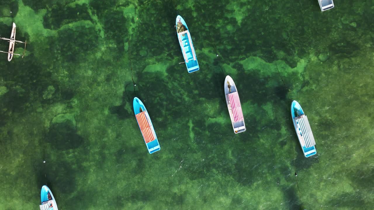 Matemwe beach, Topdown drone ascend of fishing boats over coral reef in Zanzibar’s shallow clear blue water