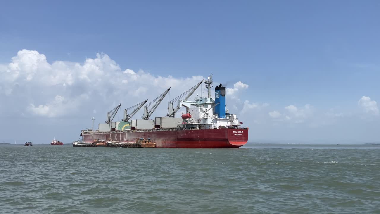 Majestic cargo ship anchored off the coast of Mumbai with clear blue skies in the background.