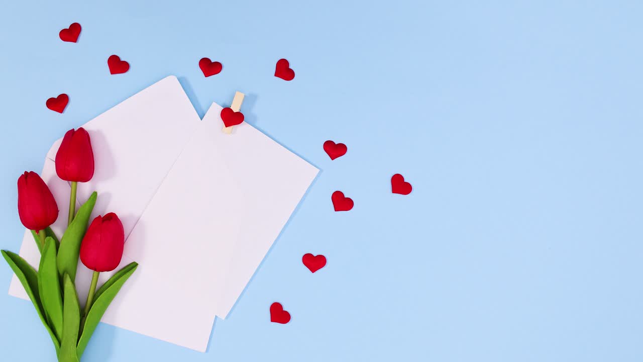발렌타인 데이를 위해 빨간 꽃과 심장을 가진 파란 테마의 봉투에서 종이가 나타납니다.