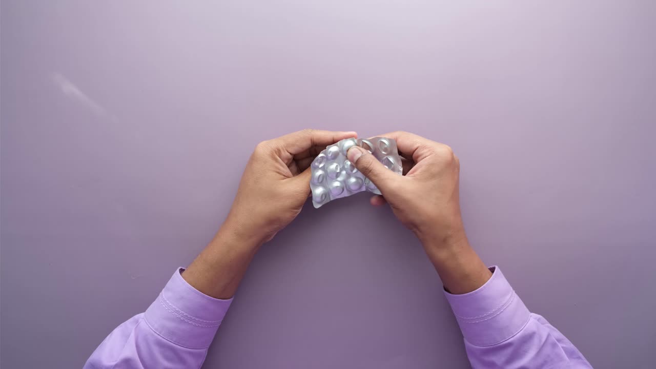 manos abriendo un blister de pastillas