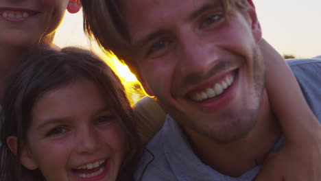 familia blanca feliz abrazándose al aire libre, de cerca