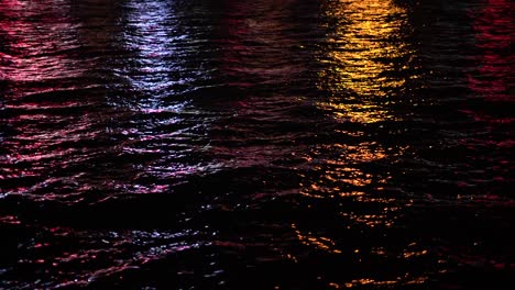 reflejo de la luz de la ciudad sobre el mar por la noche.