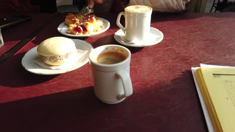 close up pastry and espresso served in morning light at a cozy café table