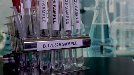 b.1.1.529 sample test tubes being placed into tube rack. static, establishing shot