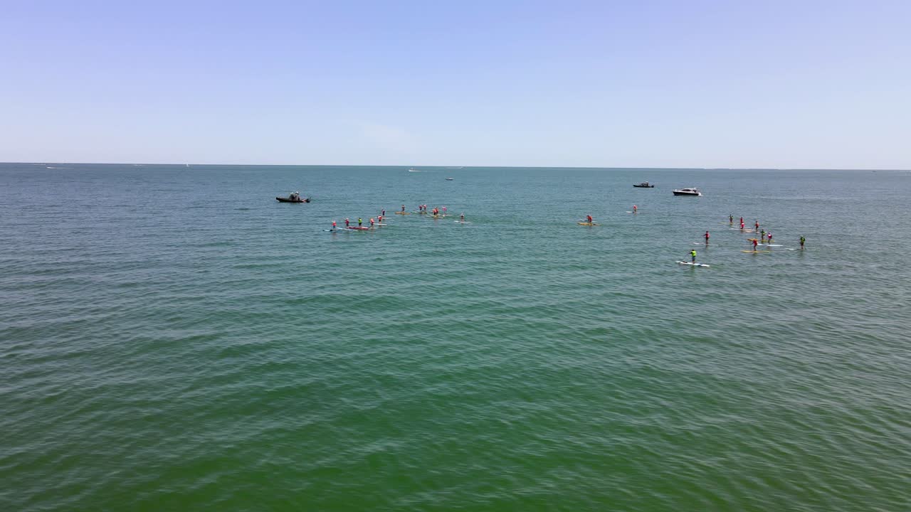 마시필드 렉사임 해변에서 스탠드업 패들 보딩 경주 이벤트를 보여주는 공중 슬라이딩 뷰