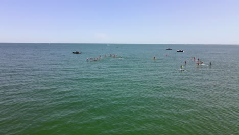 aerial sliding view showing standup paddle boarding race event on waters of rexhame beach, marshfield