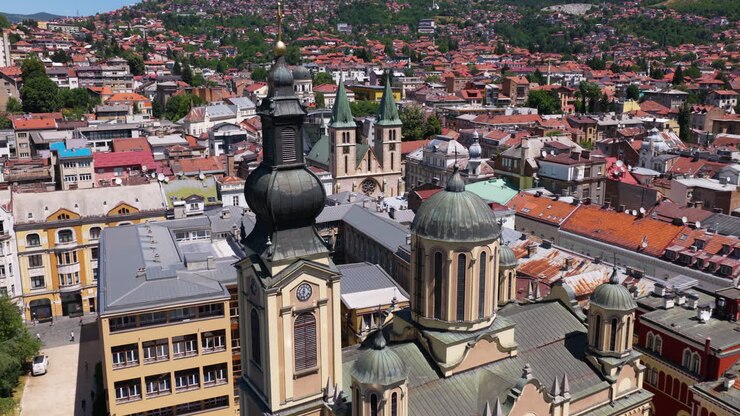 Vista aérea da Catedral do Sagrado Coração em Sarajevo, Bósnia e Herzegovina, com a Igreja Ortodoxa Sérvia revelada. Plano de afastamento.