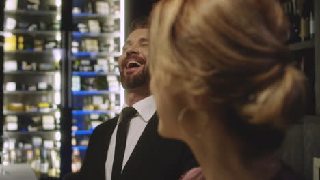 two couples having dinner, talking and smiling in a beautiful restaurant