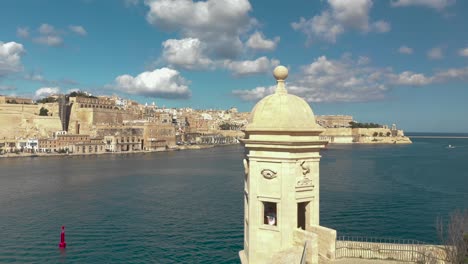 aerial shot up over a stone window towards an old city and a harbour