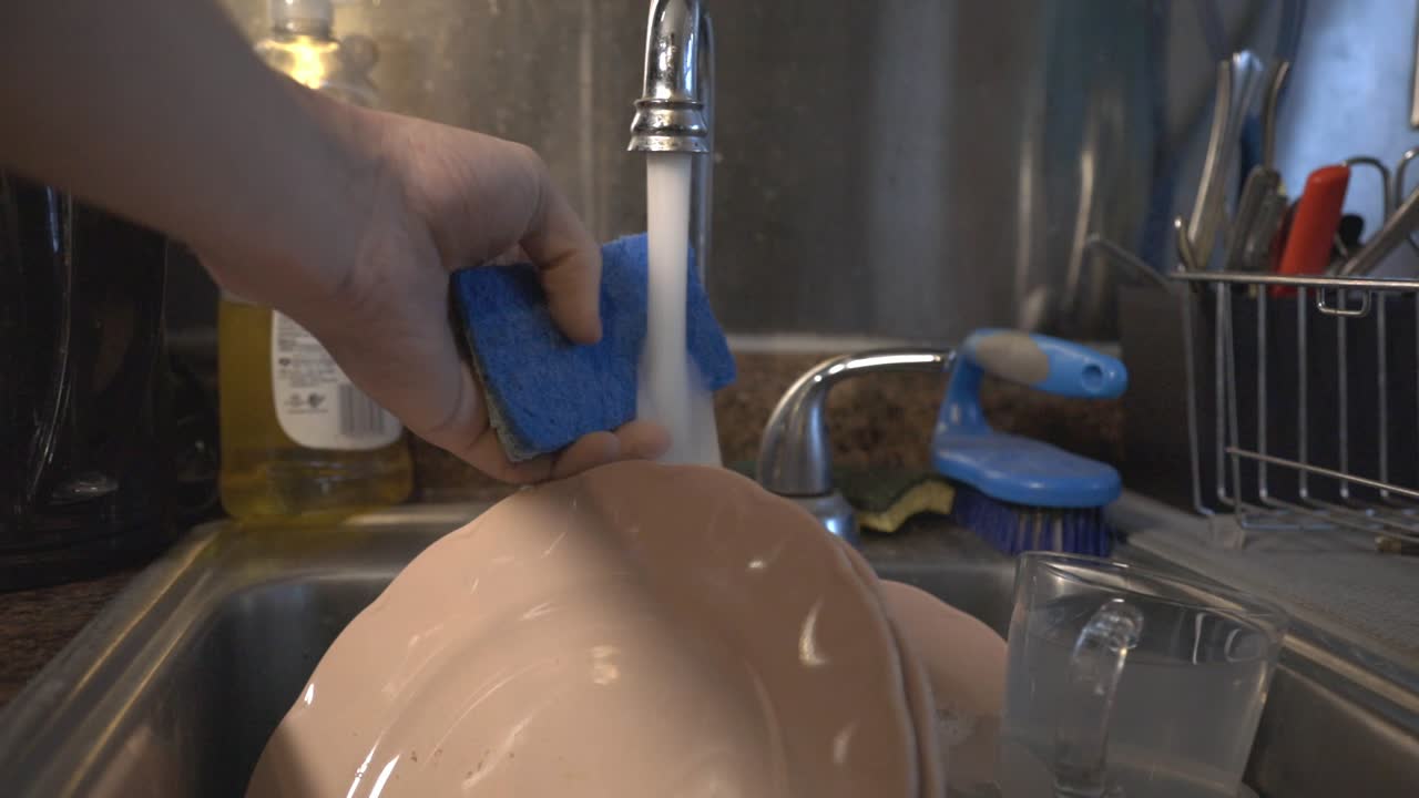 lavando platos en el fregadero de la cocina