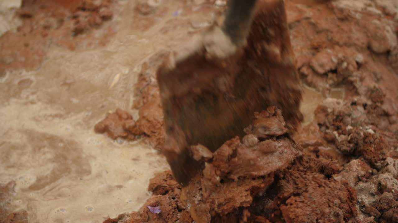 Close up of spade mixing cement - soil with water