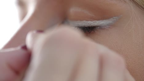 applying white eyeliner