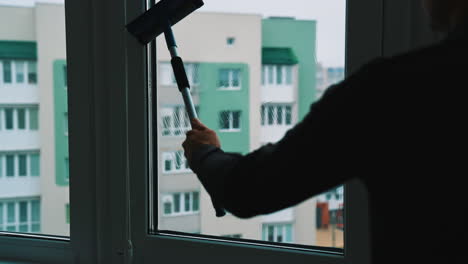 employee hand cleaning glass. washing and cleaning the window with squeegee