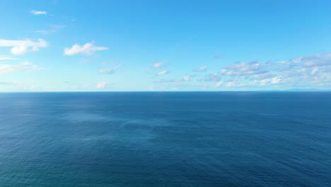 stunning aerial drone shot of the open ocean, sunlight glinting off rippling waves, capturing the tranquil yet powerful beauty of the sea in rich, vibrant, high-resolution 4k footage