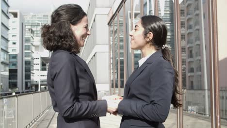 Businesswomen-greeting-each-other-and-talking-on-street