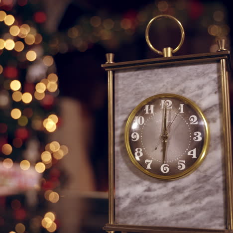 golden clock on blur christmas background. clock is showing six o'clock. the second hand moves in a circle of a mechanical clock. new year holiday. christmas concept.