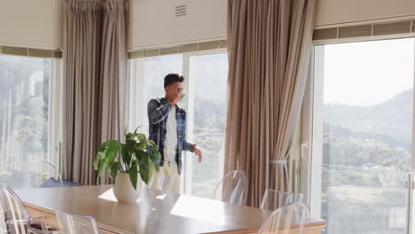 African-american-man-drinking-coffee-at-window-with-sunny-mountain-view,-copy-space,-slow-motion