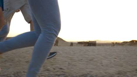 four adult people jogging on the beach