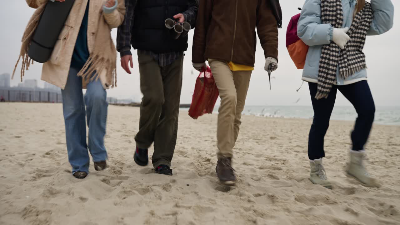 Four People Walking on a Beach in Winter