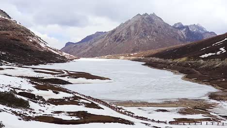 Gefrorener-Sela-see-Mit-Schneekappenbergen-Und-Hellblauem-Himmel-Am-Morgen-Aus-Einem-Flachen-Winkelvideo-Wird-In-Sela-Tawang-Arunachal-Pradesh-Indien-Aufgenommen