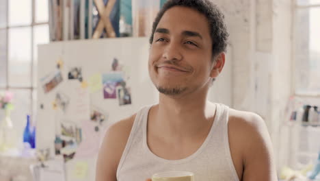 young mixed race man student drinking coffee at home in the morning