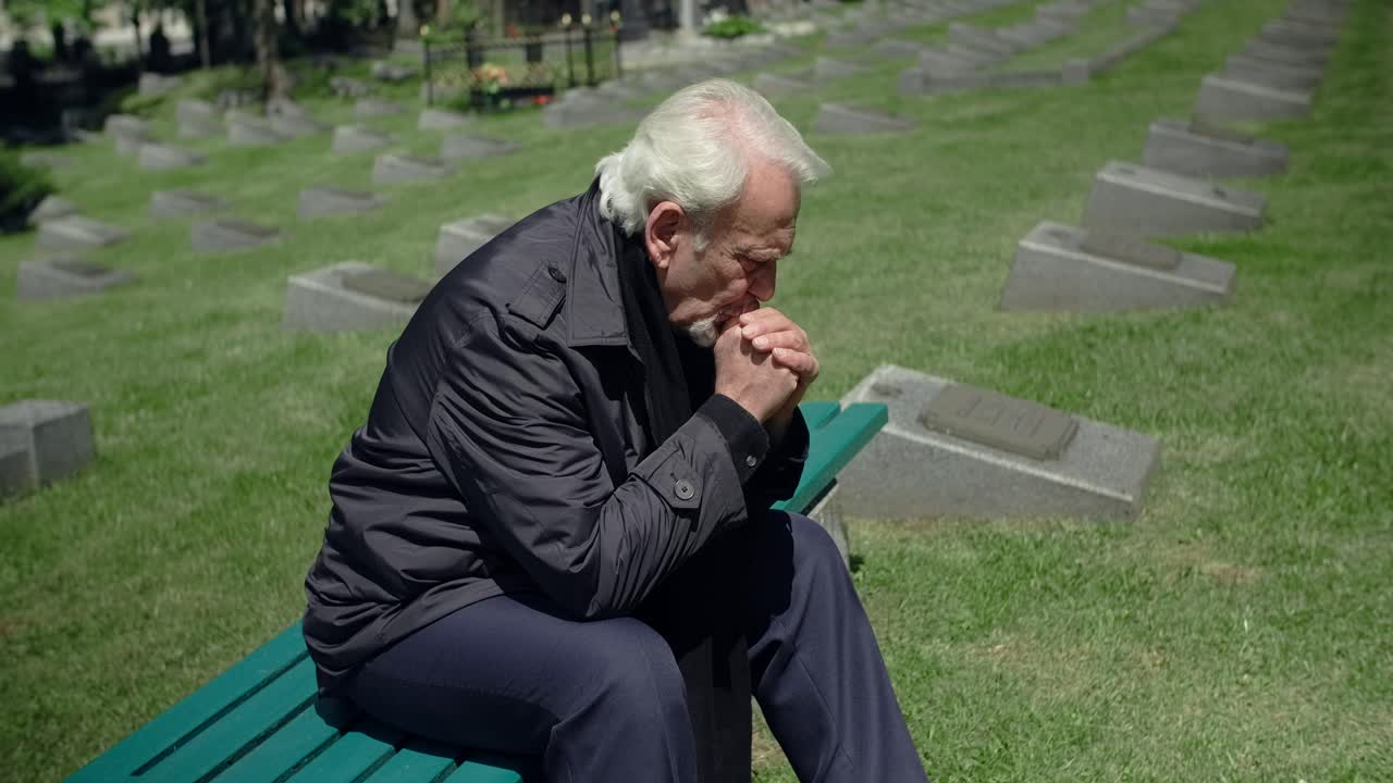 Elderly Man Mourns at Cemetery