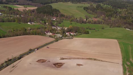 Zoom out reveals vast cultivated fields near Prague under bright spring sunlight