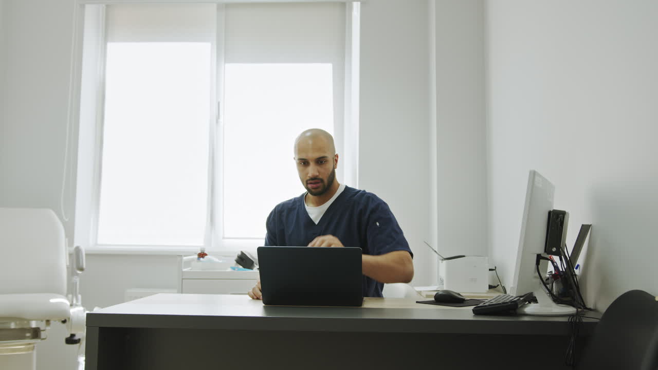 médico trabajando en una computadora portátil en la oficina
