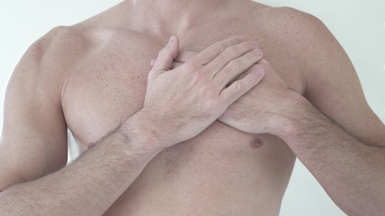 un primer plano de un hombre musculoso respirando profundamente y sintiendo su ritmo cardíaco.