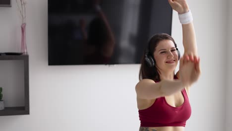 fit girl enjoying music on the phone indoor. stay at home