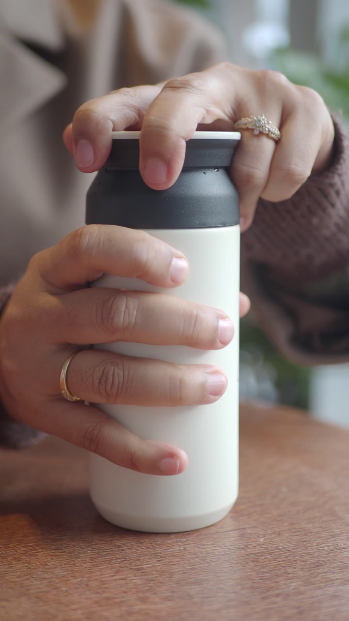 Close-up of Hands Opening and Closing a White Thermos Bottle