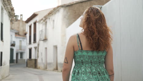 woman in green dress walking down a street