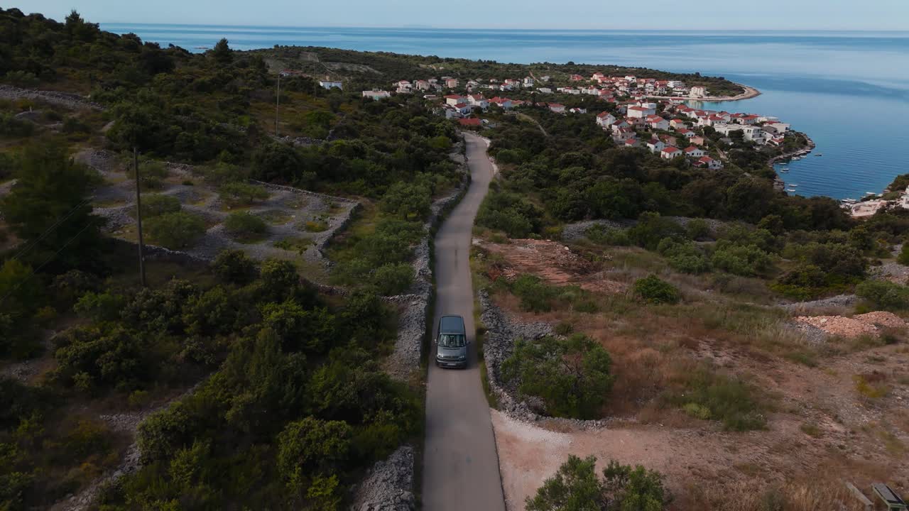 Van car drives at Kanica, captured from above with scenic countryside and coastline view, Croatia.