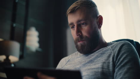 close up of financial analyst talking on phone, working on tablet computer, monitoring real-time stocks, exchange market charts. successful businessman works in comfortable office of investment bank.
