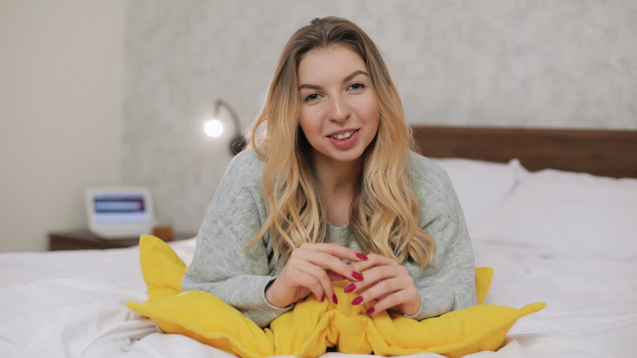 Mulher na cama fazendo streaming ou videochamada
