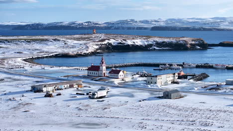 vista bajada de un dron de una iglesia tradicional en la ciudad vikinga raufarhöfn durante el invierno