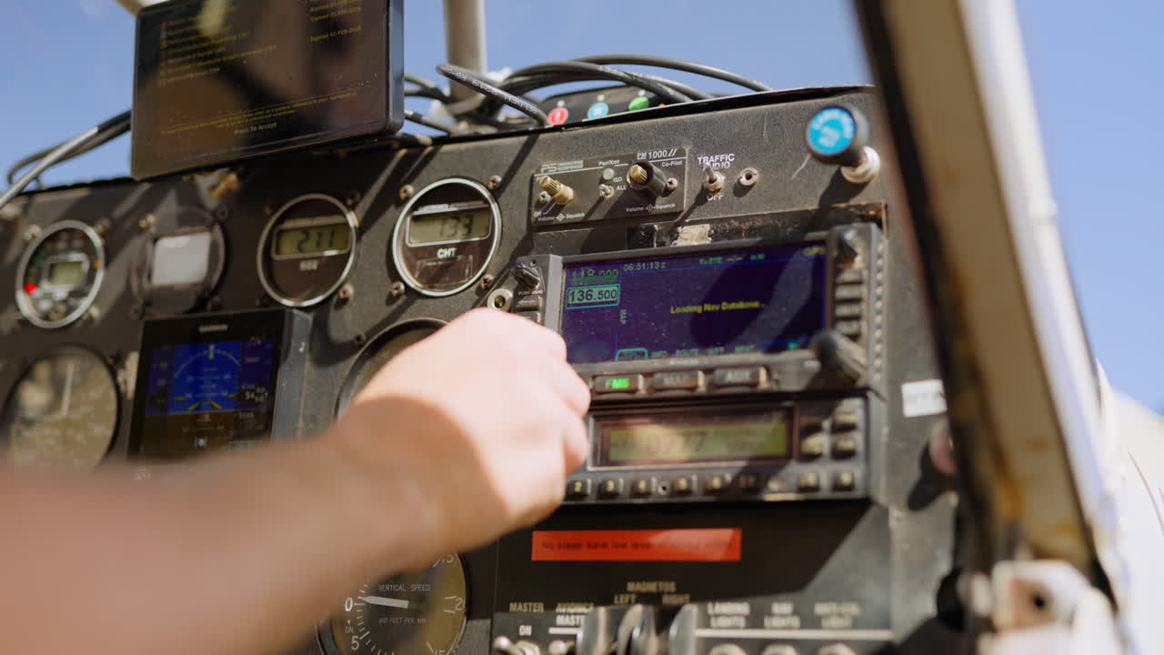 Pilota che regola il sistema di navigazione nella cabina di pilotaggio dell'aereo
