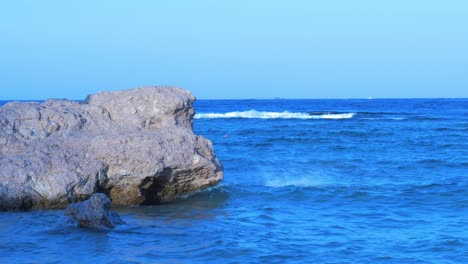 Olas-Del-Mar-Rojo-Golpeando-Las-Rocas-De-La-Costa-En-Sharm-El-Sheikh-En-Una-Tarde-Soleada,-Plano-Medio