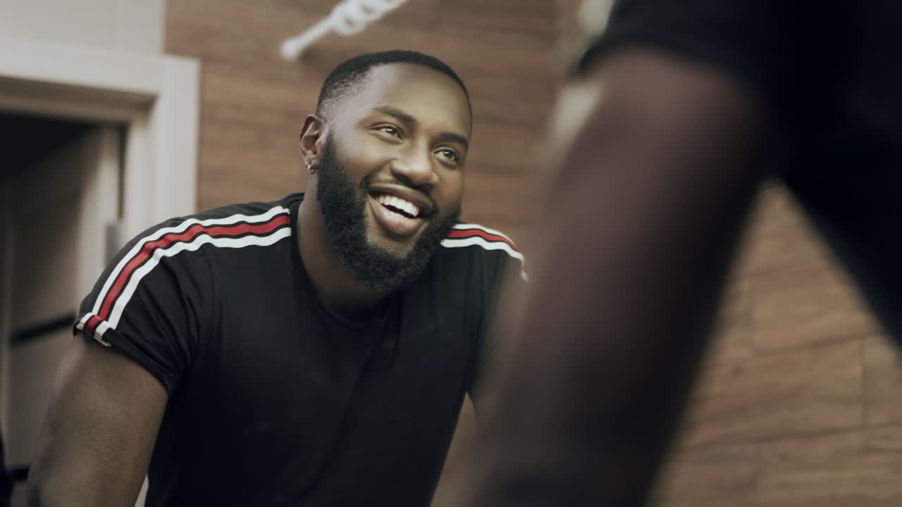 Smiling african american man looking at mirror at bathroom
