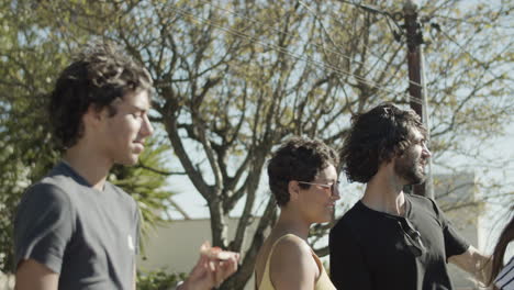 cheerful young men and women talking while having rooftop party