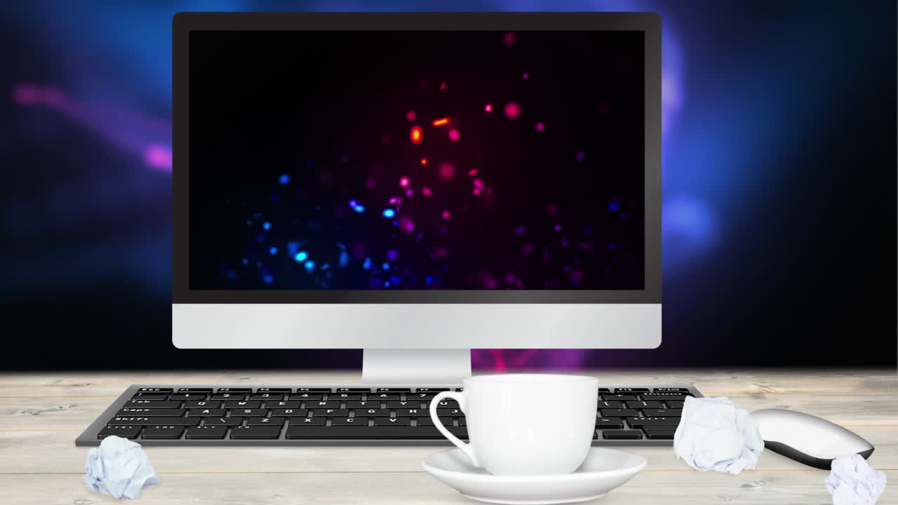 pantalla de computadora con animación colorida sobre el escritorio con taza de café y papeles arrugados