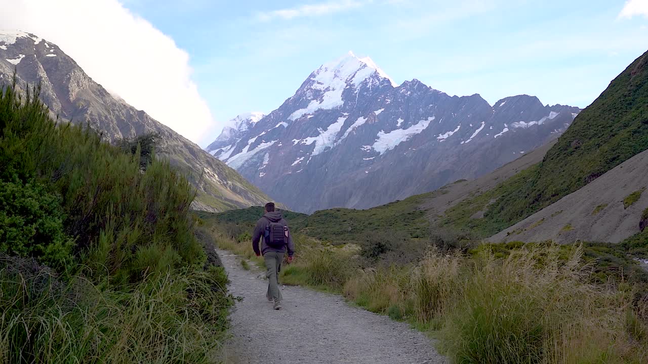 A Man walking the Hooker Valley Track in the Mt Cook Aoraki Mount Cook National Park, New Zealand. This is a popular hiking trail in New Zealands South Island