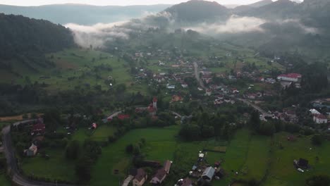 un camino sinuoso en el verde verano del pueblo de montaña de dambovicioara en rumania