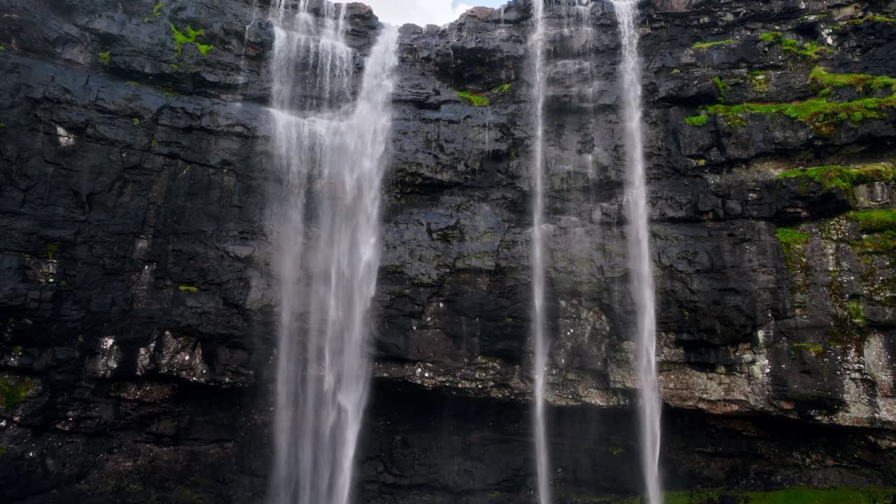 En rolig foss som fosser ned en steinete klippe på Færøyene, og fremkaller ro.