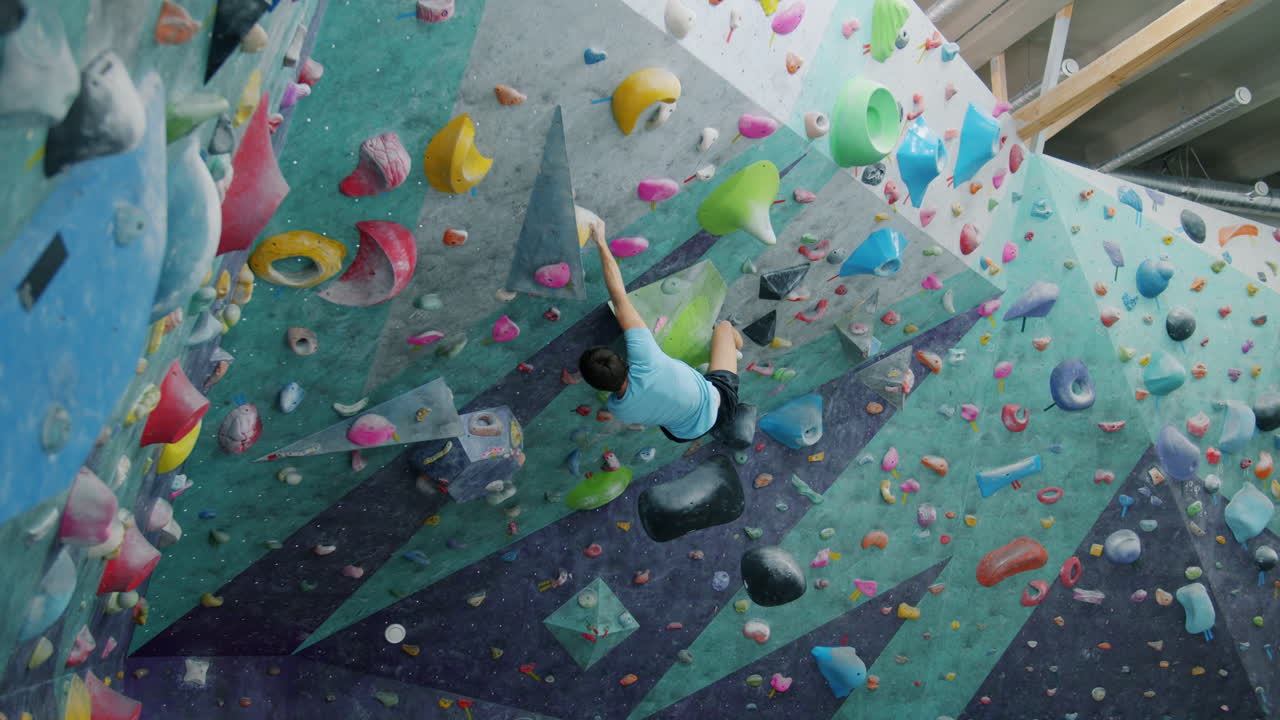 Person Climbing Indoor Bouldering Wall