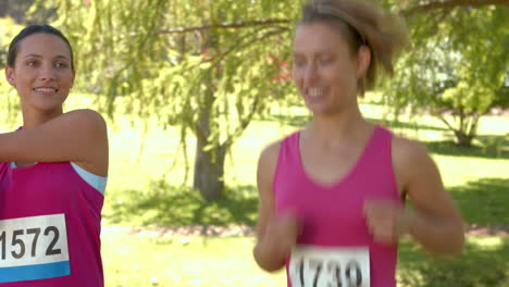 in high quality format smiling women running for breast cancer awareness