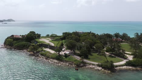 fort james antigua coastline with turquoise waters and lush greenery on a sunny day, aerial view