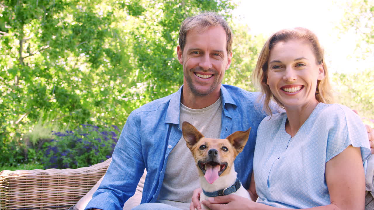 Happy white couple sitting in the garden with their pet dog | Premium ...